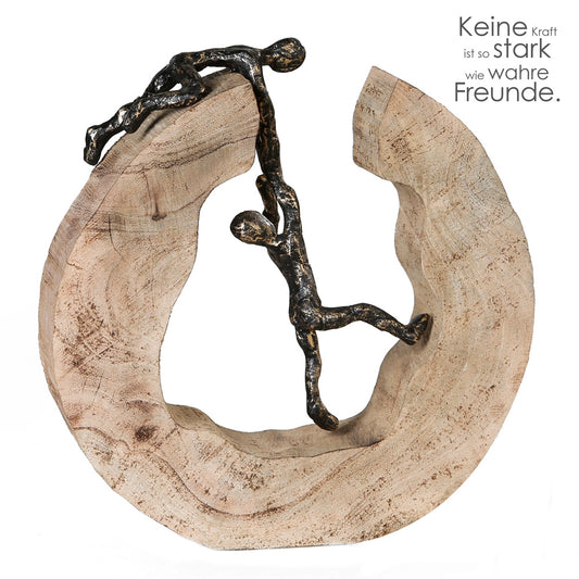 Die Skulptur "Teamwork" besteht aus einer massiven, naturbelassenen Baumscheibe aus Mango Holz. Auf und im Inneren der Skulptur befinden sich zwei miteinander verbundene Figuren, die Teamarbeit symbolisieren sollen. Der Figur im Inneren wird aus einer ausweglosen zu scheinenden Situation geholfen.