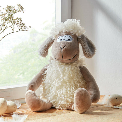 Tür- und Fensterstopper in Form eines flauschigen, sitzenden Schafs. In braun-weiß gehalten mit schwerer Sandfüllung.