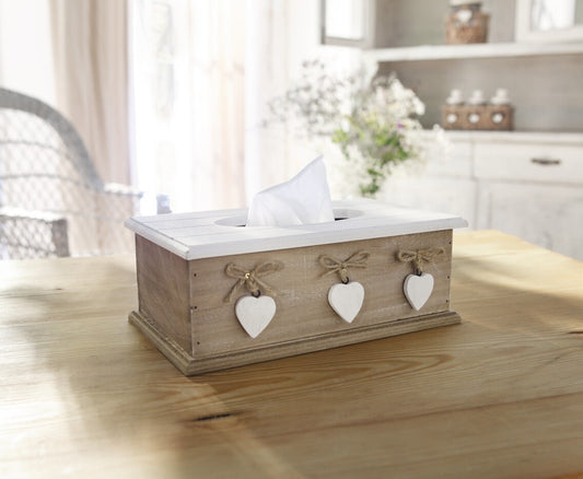 Die rechteckige Taschentuchbox im Landhausstil aus Holz, verfügt über einen praktischen, klappbaren Flachdeckel mit runder Öffnung zum Herausziehen der Taschentücher  und ist dekoriert mit kleinen, weißen Holzherzen und Schnüren