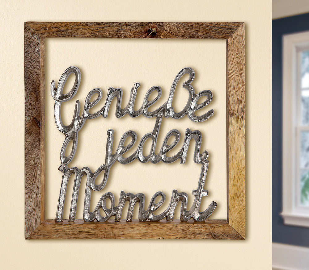 Rahmen-Wandbild "Genieße jeden Moment" aus Aluminium und Mango Holz. Brauner Holzrahmen in dem der silberne Schriftzug Genieße jeden Moment befestigt ist. Zum Hängen aber auch zum Stellen geeignet.