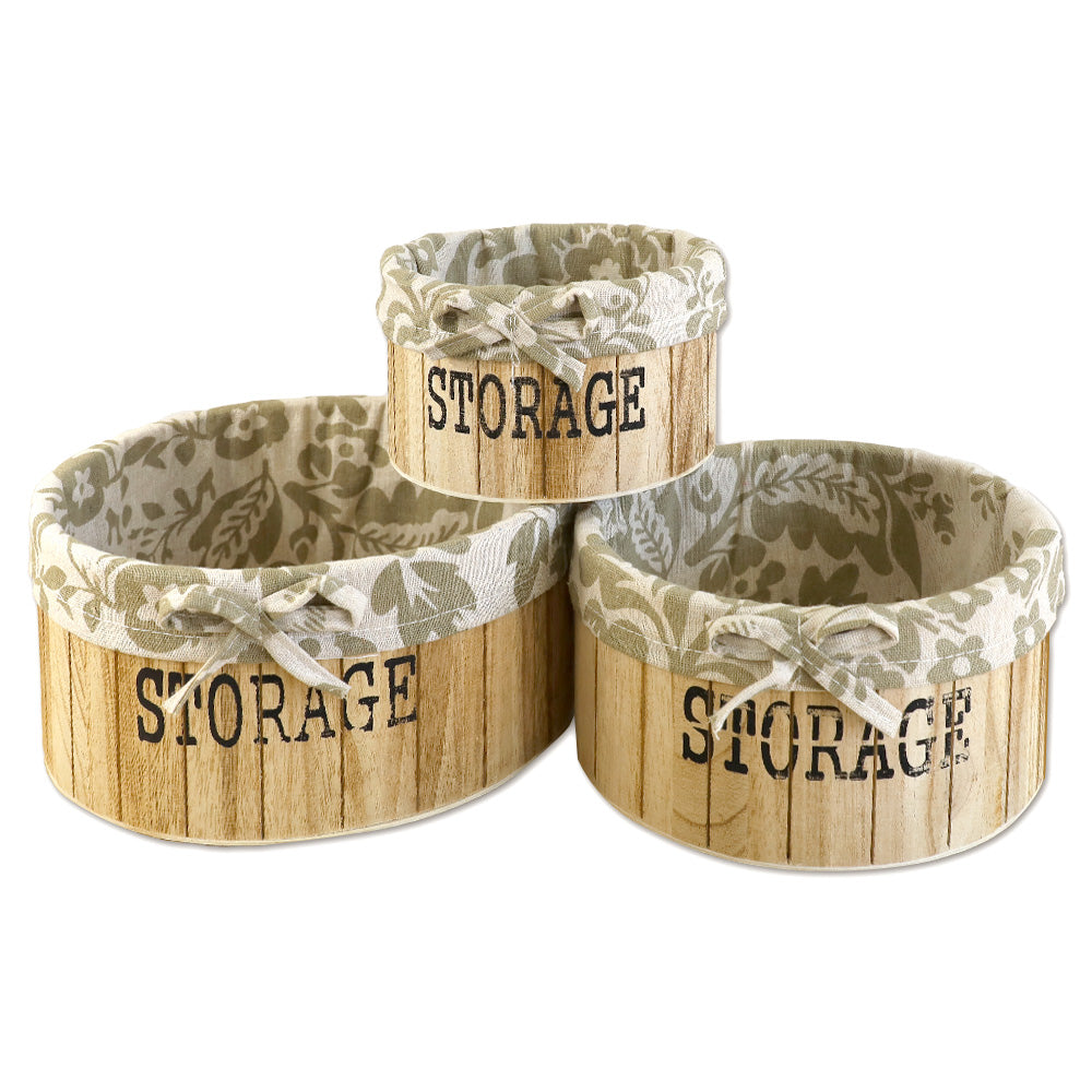 aufbewahrungskörbe aus hellbraunem holz mit der aufschrift storage und mit beige gemusterter leinenstoffeinlage. 3er set in drei unterschiedlichen größen, rund ohne deckel