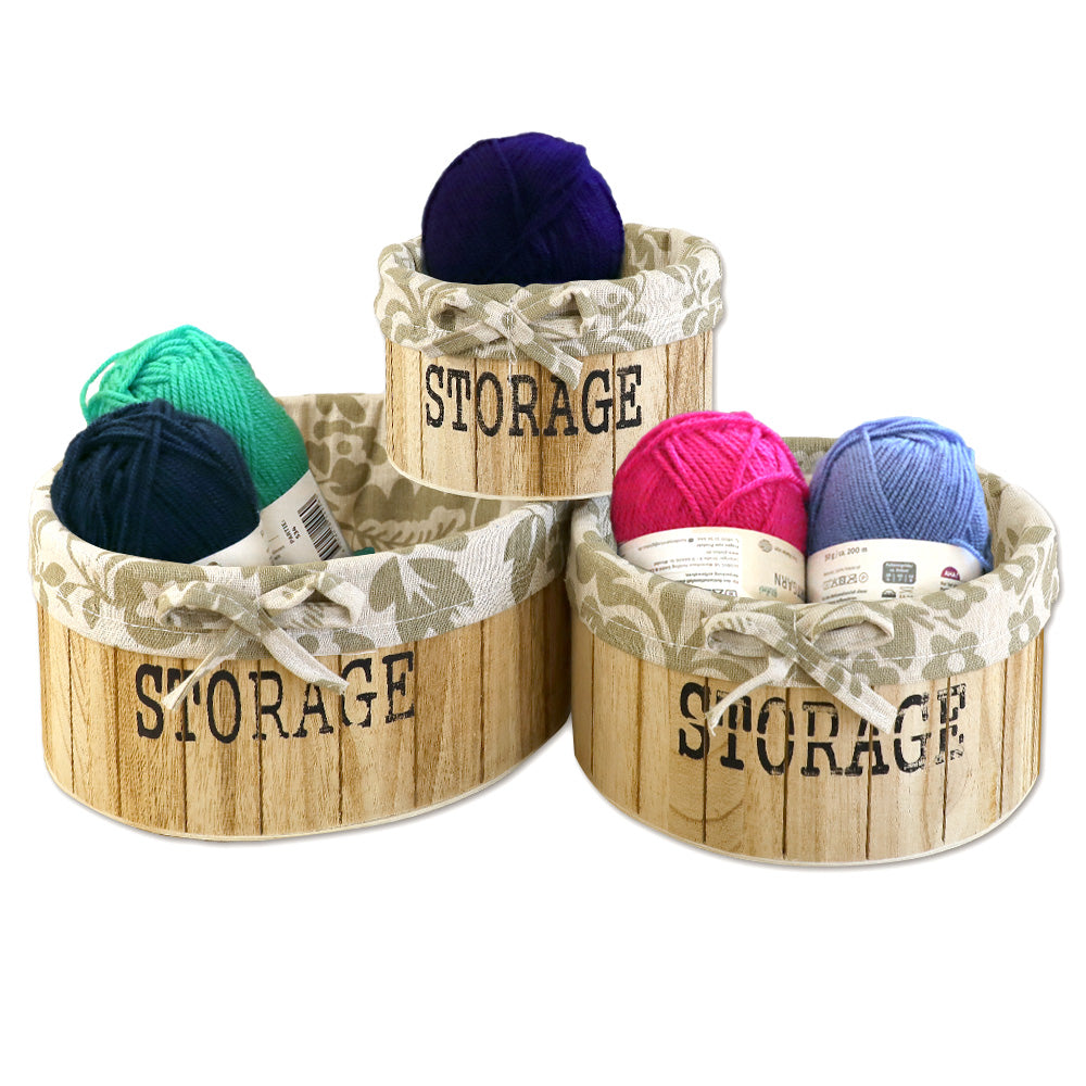 aufbewahrungskörbe aus hellbraunem holz mit der aufschrift storage und mit beige gemusterter leinenstoffeinlage. 3er set in drei unterschiedlichen größen, rund ohne deckel