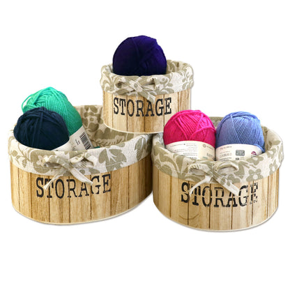 aufbewahrungskörbe aus hellbraunem holz mit der aufschrift storage und mit beige gemusterter leinenstoffeinlage. 3er set in drei unterschiedlichen größen, rund ohne deckel