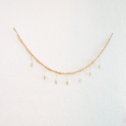 DECCARO Fotoaufhänger Cord, Fotoaufhänger aus einer hellen horizontalen Baumwollschnur auf die hellen Holzperlen aufgereiht sind. An dieser Schnur sind sechs vertikal ausgerichtete Baumwollschnüre mit Holzperlen und kleinen Holzklammern befestigt, an den Fotos und Postkarten aufgehangen werden können. 