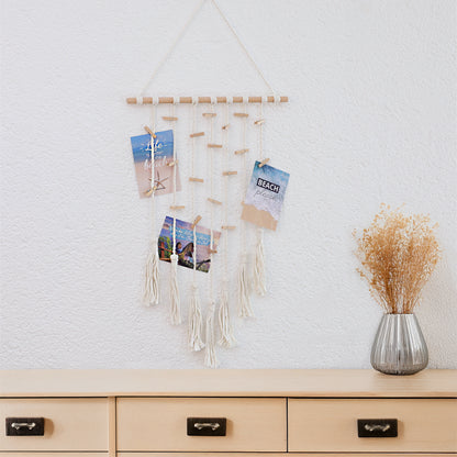 Makramee Fotoaufhänger Collage, handgefertigter Fotoaufhänger im trendigen Makramee-Stil. Horizontal angebrachter Holzstab an dem Baumwollseile, Quasten und Mini-Holzklammern angebracht sind, an denen die Fotos oder Postkarten aufgehangen werden können.