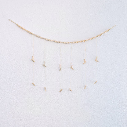 DECCARO Fotoaufhänger Cord, Fotoaufhänger aus einer hellen horizontalen Baumwollschnur auf die hellen Holzperlen aufgereiht sind. An dieser Schnur sind sechs vertikal ausgerichtete Baumwollschnüre mit Holzperlen und kleinen Holzklammern befestigt, an den Fotos und Postkarten aufgehangen werden können. 