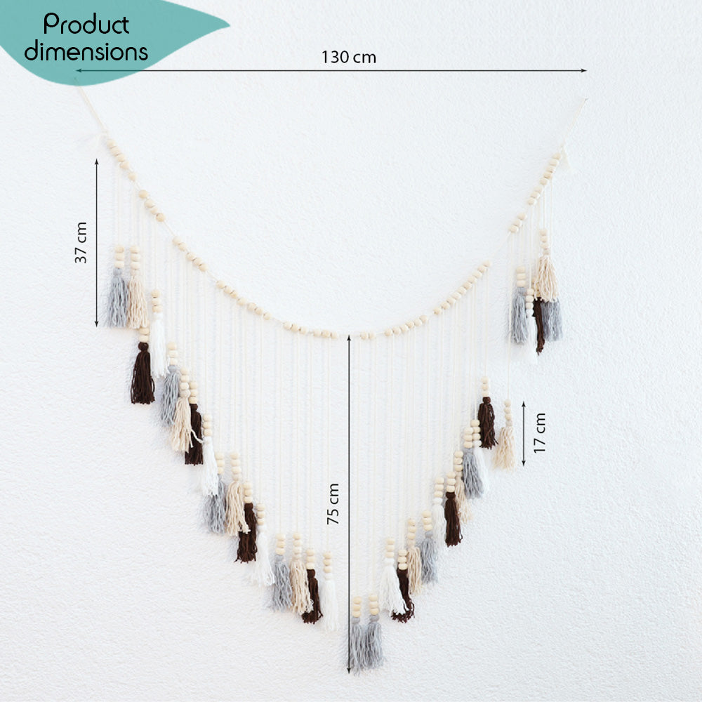 DECCARO Makramee Girlande Tassel. Kombination aus naturfarbenem Baumwollseil mit kleinen Holzperlen und vom Baumwollseil nach unten hängenden Baumwollquasten in den Farben weiß, beige, grau und braun. Oberhalb der Quasten befinden sich an jeder Quaste je drei Holzperlen.