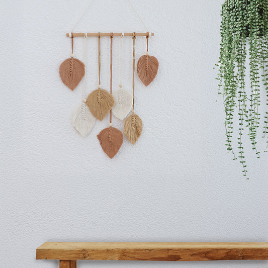 DECCARO Makramee Wanddekoration „Bar“ ockerfarben im Boho-Stil. Naturbelassene horizontale Holzstange an der Baumwollseile mit Holzperlen befestigt sind. Das Ende der Baumwollseile bilden creme, beige und ockerfarbene Baumwollschnüre in Blätteroptik. 