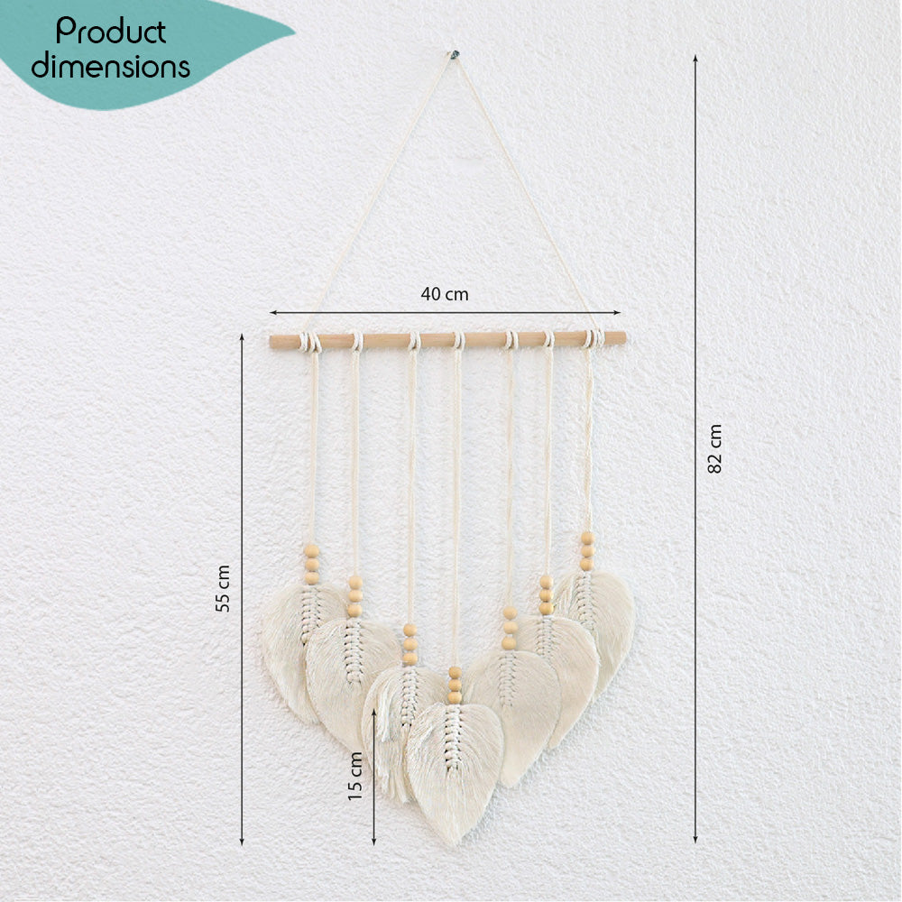 DECCARO Makramee Wanddekoration „Bar“ im Boho-Stil. Naturbelassene horizontale Holzstange an der cremefarbene Baumwollseile mit Holzperlen befestigt sind. Das Ende der Baumwollseile bilden creme Baumwollschnüre in Blätteroptik. 