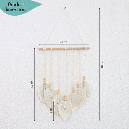 DECCARO Makramee Wanddekoration „Bar“ im Boho-Stil. Naturbelassene horizontale Holzstange an der cremefarbene Baumwollseile mit Holzperlen befestigt sind. Das Ende der Baumwollseile bilden creme Baumwollschnüre in Blätteroptik. 