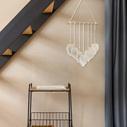 DECCARO Makramee Wanddekoration „Bar“ im Boho-Stil. Naturbelassene horizontale Holzstange an der cremefarbene Baumwollseile mit Holzperlen befestigt sind. Das Ende der Baumwollseile bilden creme Baumwollschnüre in Blätteroptik. 