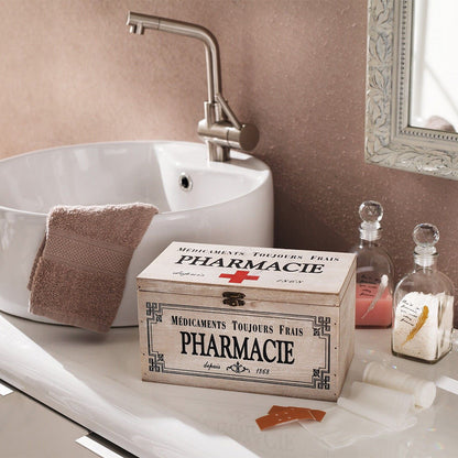 Dekobox im Vintage-Stil aus weiß gekalktem Holz im Shabby-Stil mit der dekorative französische Aufdruck „Pharmacie“ und einem roten Kreuz auf dem Klappdeckel, verziert mit einer Metallschnalle für den Verschluss der Box