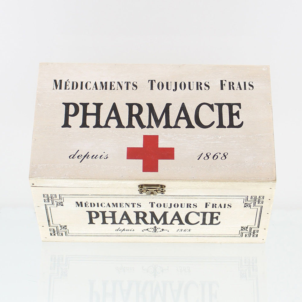 Dekobox im Vintage-Stil aus weiß gekalktem Holz im Shabby-Stil mit der dekorative französische Aufdruck „Pharmacie“ und einem roten Kreuz auf dem Klappdeckel, verziert mit einer Metallschnalle für den Verschluss der Box