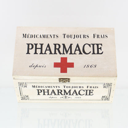 Dekobox im Vintage-Stil aus weiß gekalktem Holz im Shabby-Stil mit der dekorative französische Aufdruck „Pharmacie“ und einem roten Kreuz auf dem Klappdeckel, verziert mit einer Metallschnalle für den Verschluss der Box