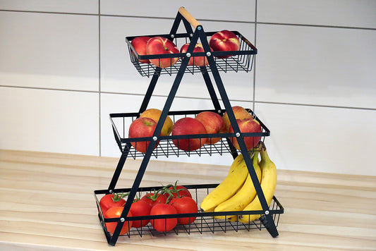 DECCARO Obstkorb/Etagere aus Metall, 3-stöckig, schwarz. Dreieckige Form mit drei Metallgitter Etagen die unterschiedlich lang sind und hellem Holzgriff am oberen, eckigen Ende.