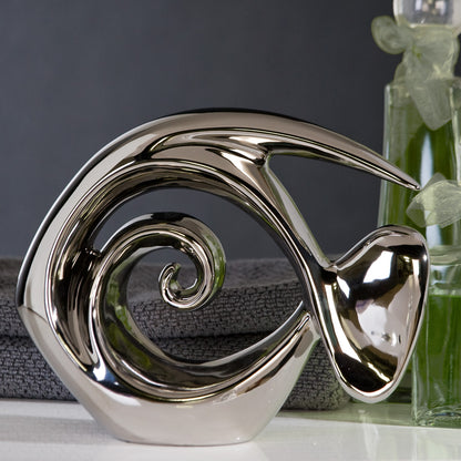 Figur Fisch "Atlantik" in abstrakter Fisch Form.. Flossen, Mund und Augen sind l durch geschwungene Formen angedeutet. Der Artikel ist aus silber glasierter Keramik gefertigt.