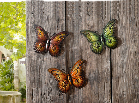 Dekorative Schmetterlinge im dreier Set aus filigran ausgestanztem Metall, in braun, orange und grün bemalt. 